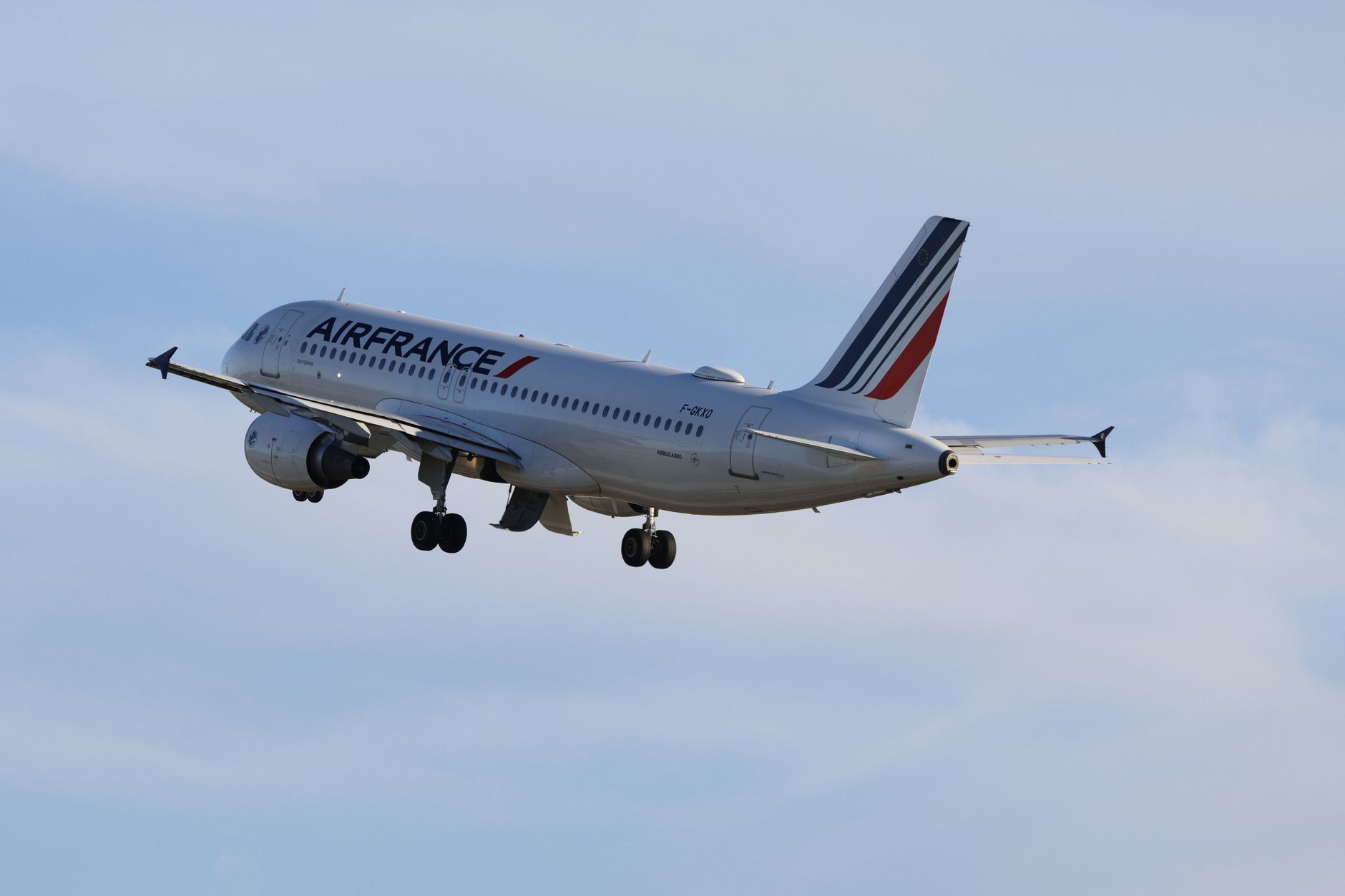 Air France Airbus A320 flying against a clear blue sky, showcasing aviation travel.